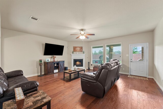 24506 Rossmore Hill Ct, Spring, TX 77389 - living room featuring ceiling fan, wood finished floors, and a lit fireplace