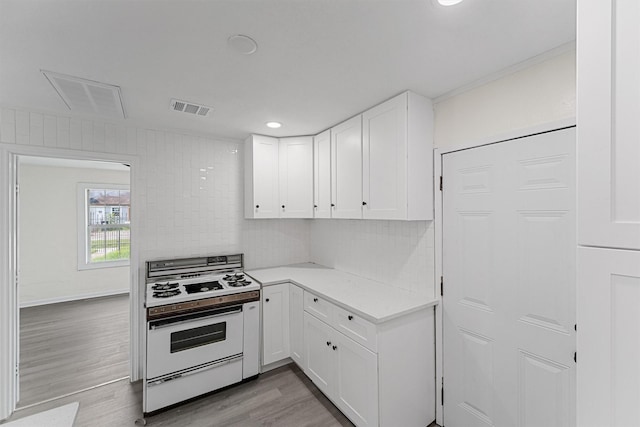4715 Engleford St, Houston, TX 77026 - kitchen featuring white range oven, backsplash, white cabinetry, light countertops, and recessed lighting