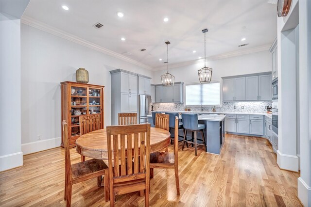 7119 Janet St, Houston, TX 77055 - dining area featuring light wood finished floors, recessed lighting, crown molding, and a chandelier