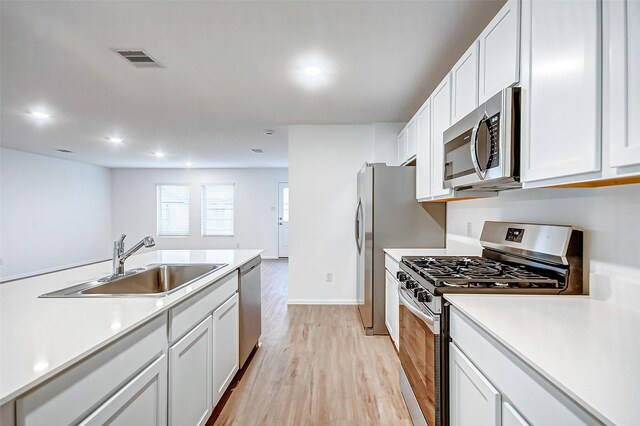 9603 Fulvetta Briar Ct, Baytown, TX 77521 - kitchen featuring stainless steel appliances, light wood-style flooring, white cabinets, light countertops, and recessed lighting