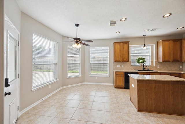 2219 Fenton Rock Ln, Katy, TX 77494 - kitchen featuring black dishwasher, brown cabinets, healthy amount of natural light, recessed lighting, and a textured ceiling