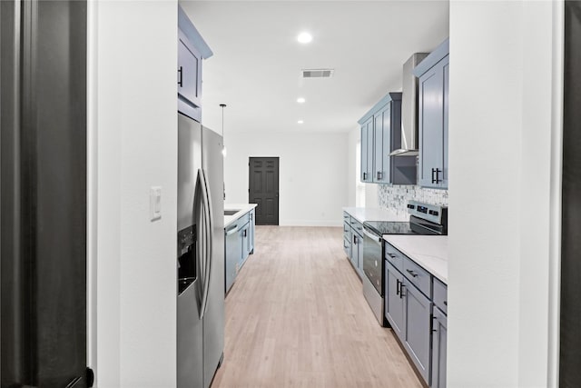 8136 Chateau St, Houston, TX 77028 - kitchen with appliances with stainless steel finishes, wall chimney range hood, light wood-style flooring, tasteful backsplash, and recessed lighting