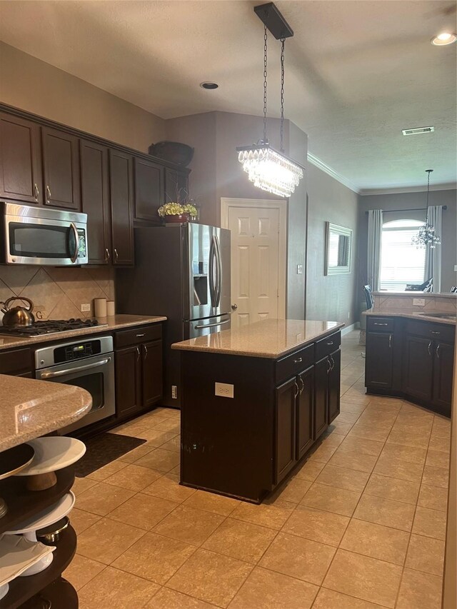6315 Oakmont Creek Dr, Spring, TX 77379 - kitchen featuring stainless steel appliances, tasteful backsplash, crown molding, decorative light fixtures, and light tile patterned floors