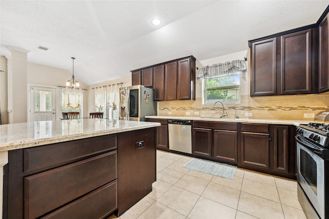 12747 Bridle Springs Ln, Houston, TX 77044 - kitchen with appliances with stainless steel finishes, tasteful backsplash, vaulted ceiling, dark brown cabinets, and a chandelier