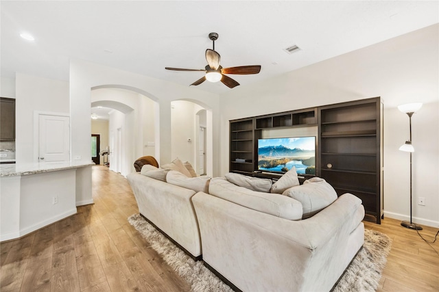 12747 Bridle Springs Ln, Houston, TX 77044 - living area with arched walkways, ceiling fan, light wood-type flooring, and built in features