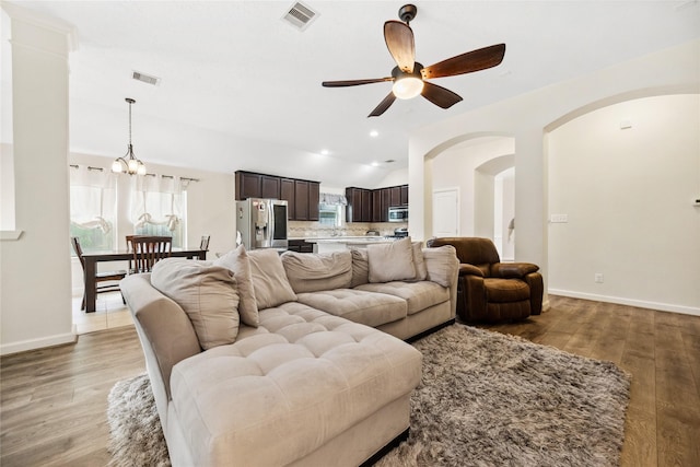 12747 Bridle Springs Ln, Houston, TX 77044 - living area with ceiling fan, vaulted ceiling, a chandelier, light wood-type flooring, and arched walkways