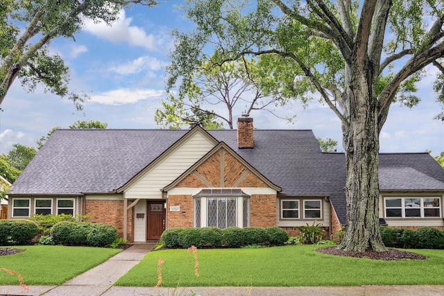 5707 Darnell St, Houston, TX 77096 - tudor home with brick siding, a front lawn, a chimney, and a shingled roof