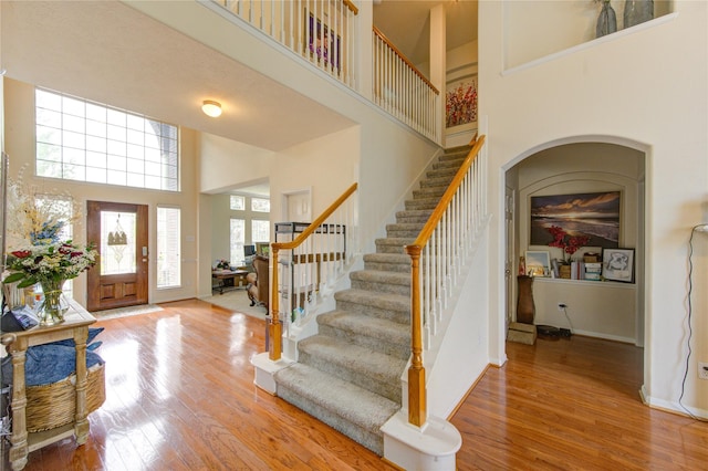 24811 Corbin Gate Dr, Spring, TX 77389 - foyer entrance featuring a high ceiling, wood finished floors, stairway, and arched walkways