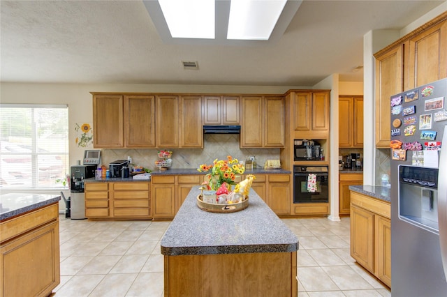 24811 Corbin Gate Dr, Spring, TX 77389 - kitchen with black appliances, extractor fan, light tile patterned floors, tasteful backsplash, and a kitchen island