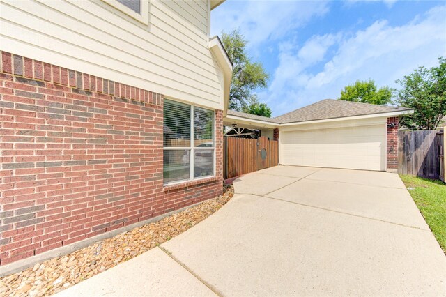 24811 Corbin Gate Dr, Spring, TX 77389 - view of side of home featuring concrete driveway, an attached garage, and brick siding