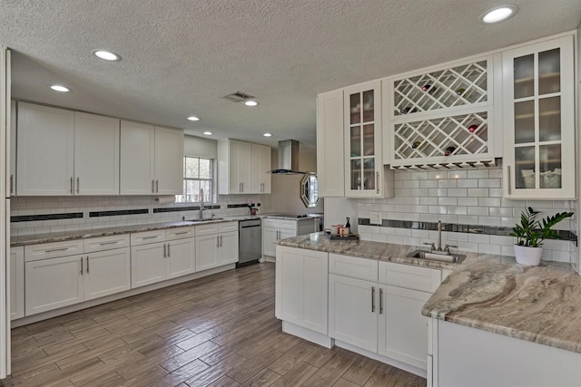 24203 Creekview Dr, Spring, TX 77389 - kitchen featuring dishwasher, a textured ceiling, wall chimney range hood, backsplash, and white cabinets