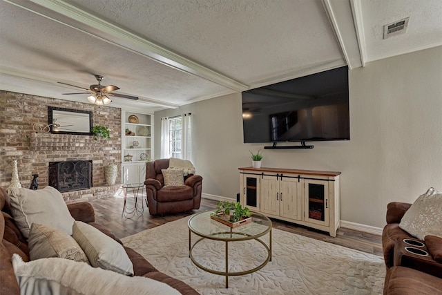 24203 Creekview Dr, Spring, TX 77389 - living room featuring a textured ceiling, wood finished floors, a fireplace, a ceiling fan, and crown molding