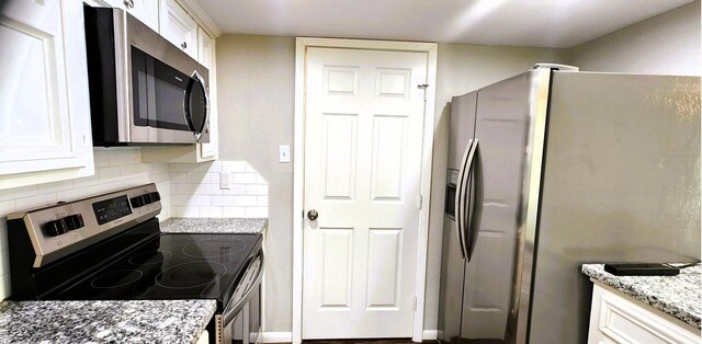 14777 Wunderlich Dr Unit 605, Houston, TX 77069 - kitchen with appliances with stainless steel finishes, decorative backsplash, light stone counters, and white cabinets