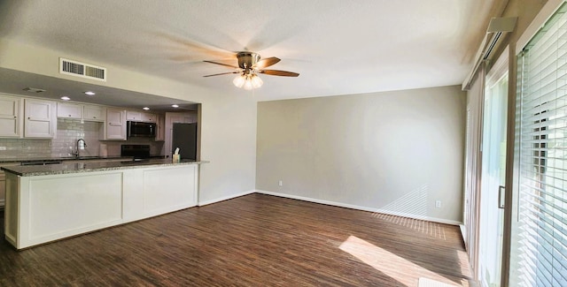 14777 Wunderlich Dr Unit 605, Houston, TX 77069 - kitchen with freestanding refrigerator, black microwave, ceiling fan, dark stone countertops, and dark wood finished floors