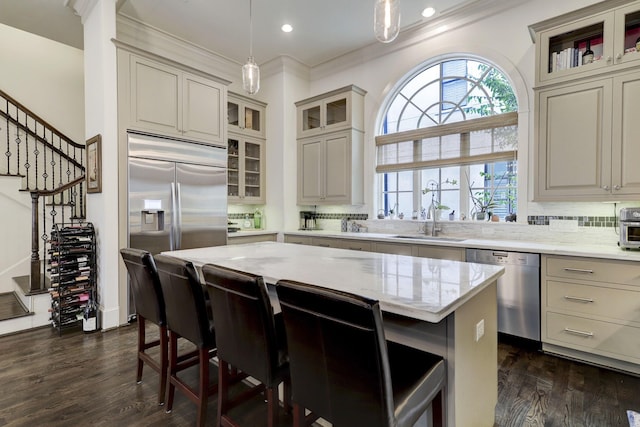 5218 Crawford St, Houston, TX 77004 - kitchen with stainless steel appliances, a breakfast bar, decorative backsplash, light stone counters, and ornamental molding