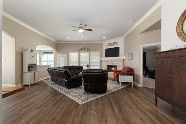 1803 Twin Oaks Cir, Brenham, TX 77833 - living area with ceiling fan, dark wood-style floors, a stone fireplace, crown molding, and arched walkways