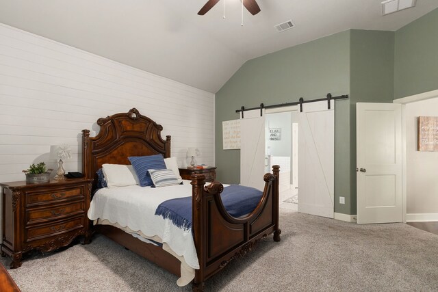 1803 Twin Oaks Cir, Brenham, TX 77833 - carpeted bedroom featuring a barn door, vaulted ceiling, ceiling fan, and wood walls