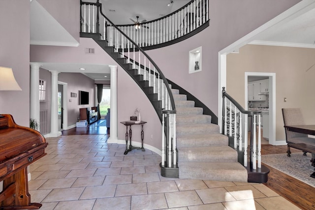 210 River Oaks Dr, Lake Jackson, TX 77566 - foyer featuring decorative columns, stairs, crown molding, a towering ceiling, and tile patterned flooring