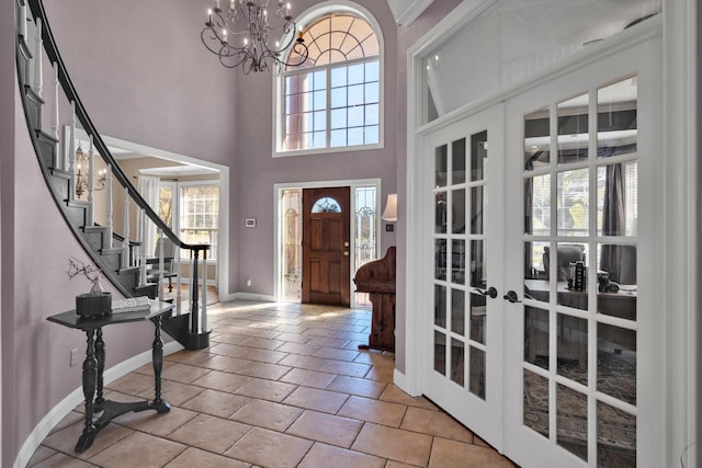 210 River Oaks Dr, Lake Jackson, TX 77566 - entrance foyer featuring french doors, a chandelier, stairway, light tile patterned flooring, and a towering ceiling