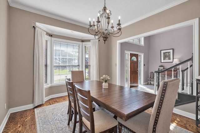 210 River Oaks Dr, Lake Jackson, TX 77566 - dining room with a chandelier, healthy amount of natural light, crown molding, wood finished floors, and stairs
