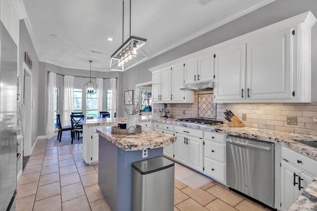 210 River Oaks Dr, Lake Jackson, TX 77566 - kitchen with stainless steel appliances, a chandelier, under cabinet range hood, tasteful backsplash, and white cabinets