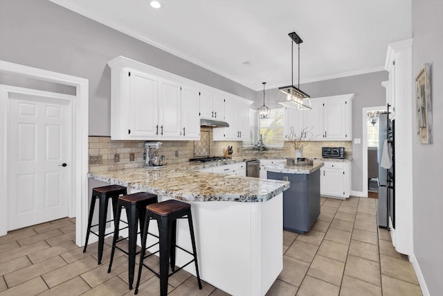210 River Oaks Dr, Lake Jackson, TX 77566 - kitchen featuring a peninsula, under cabinet range hood, white cabinets, decorative backsplash, and appliances with stainless steel finishes