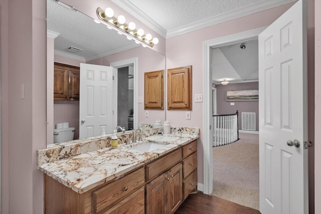 210 River Oaks Dr, Lake Jackson, TX 77566 - bathroom with a textured ceiling, vanity, crown molding, and wood finished floors