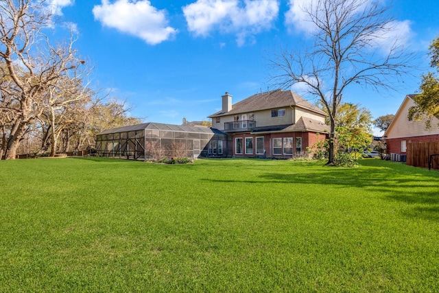 210 River Oaks Dr, Lake Jackson, TX 77566 - rear view of property with a lawn, a chimney, and glass enclosure