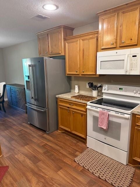 240 Rosalie St, Shepherd, TX 77371 - kitchen with white appliances, dark wood-style flooring, light countertops, brown cabinets, and a textured ceiling