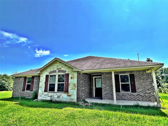 240 Rosalie St, Shepherd, TX 77371 - ranch-style home with a front yard, brick siding, stone siding, and roof with shingles