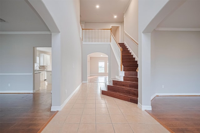 11107 Camino Oaks Dr, Houston, TX 77064 - entrance foyer featuring arched walkways, crown molding, stairs, recessed lighting, and light tile patterned floors