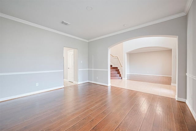11107 Camino Oaks Dr, Houston, TX 77064 - spare room featuring arched walkways, wood finished floors, ornamental molding, and stairway