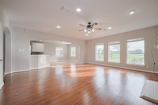 11107 Camino Oaks Dr, Houston, TX 77064 - unfurnished living room featuring arched walkways, ceiling fan, light wood-style floors, and recessed lighting