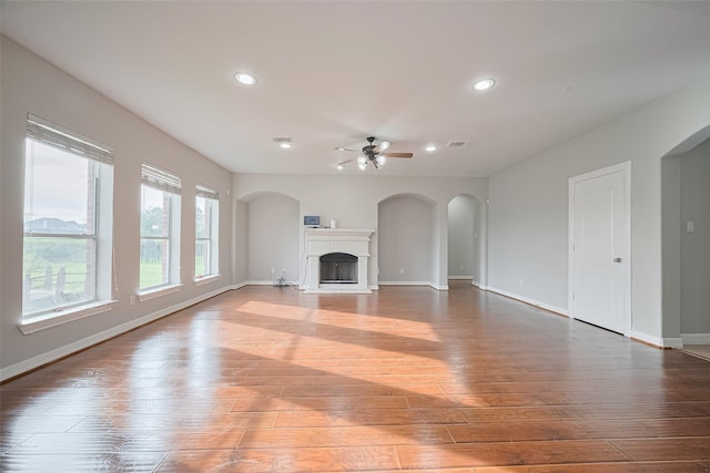 11107 Camino Oaks Dr, Houston, TX 77064 - unfurnished living room with ceiling fan, hardwood / wood-style floors, recessed lighting, arched walkways, and a fireplace