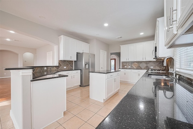 11107 Camino Oaks Dr, Houston, TX 77064 - kitchen with appliances with stainless steel finishes, tasteful backsplash, white cabinets, a kitchen island, and recessed lighting