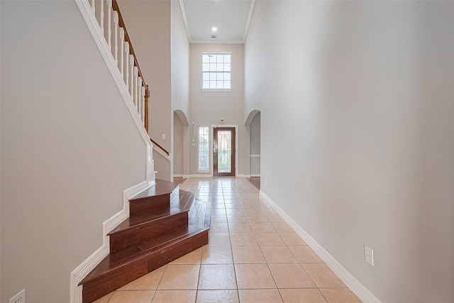 11107 Camino Oaks Dr, Houston, TX 77064 - entrance foyer with arched walkways, light tile patterned flooring, stairway, ornamental molding, and a towering ceiling