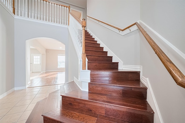 11107 Camino Oaks Dr, Houston, TX 77064 - stairs featuring arched walkways, a towering ceiling, and tile patterned floors