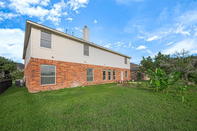 11107 Camino Oaks Dr, Houston, TX 77064 - rear view of house with brick siding, a chimney, and a yard