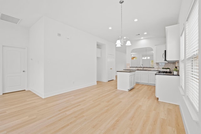 506 Mornington Ln, Katy, TX 77494 - kitchen with a chandelier, arched walkways, recessed lighting, tasteful backsplash, and light wood finished floors