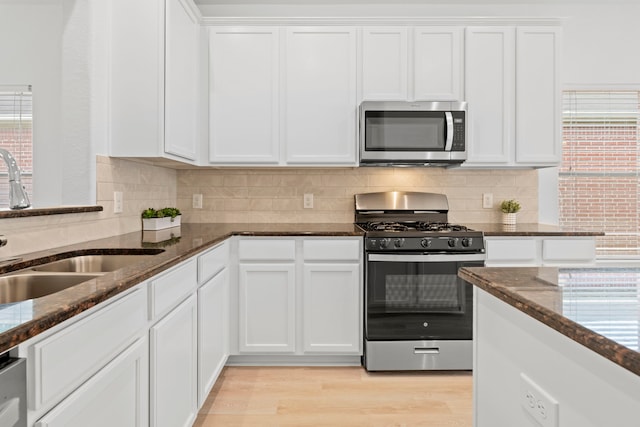 506 Mornington Ln, Katy, TX 77494 - kitchen featuring stainless steel appliances, dark stone countertops, and white cabinetry