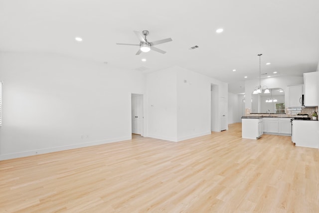 506 Mornington Ln, Katy, TX 77494 - unfurnished living room featuring recessed lighting, a ceiling fan, light wood-style flooring, and a chandelier