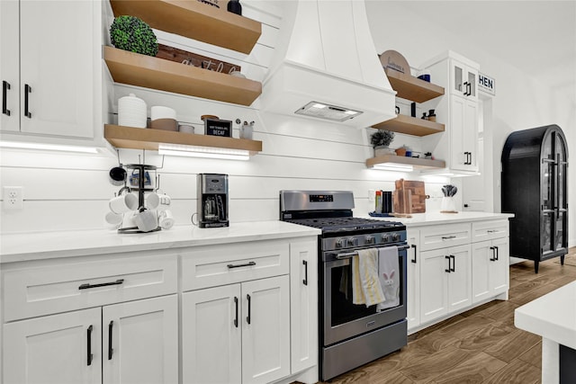 960 Rd 6609, Dayton, TX 77535 - kitchen with open shelves, stainless steel range with gas stovetop, custom range hood, and white cabinetry