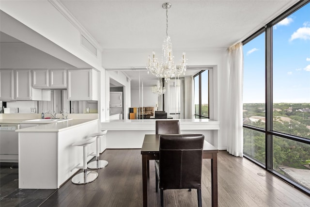1111 Bering Dr Unit 805, Houston, TX 77057 - kitchen with stacked washer and clothes dryer, a chandelier, dishwasher, light countertops, and a peninsula
