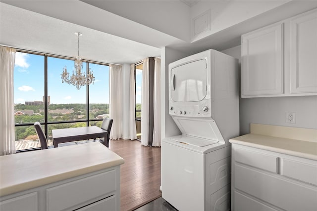 1111 Bering Dr Unit 805, Houston, TX 77057 - laundry room with stacked washing machine and dryer, a chandelier, and dark wood finished floors