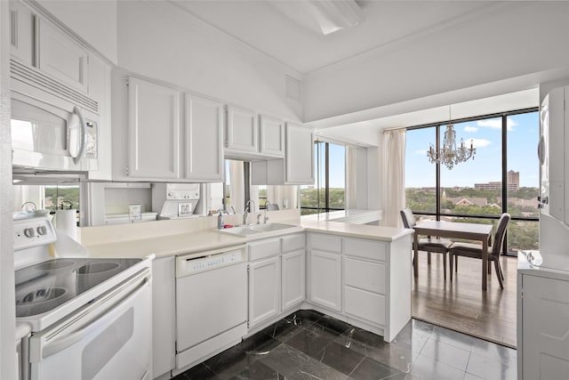 1111 Bering Dr Unit 805, Houston, TX 77057 - kitchen featuring white appliances, a chandelier, ornamental molding, white cabinets, and a peninsula