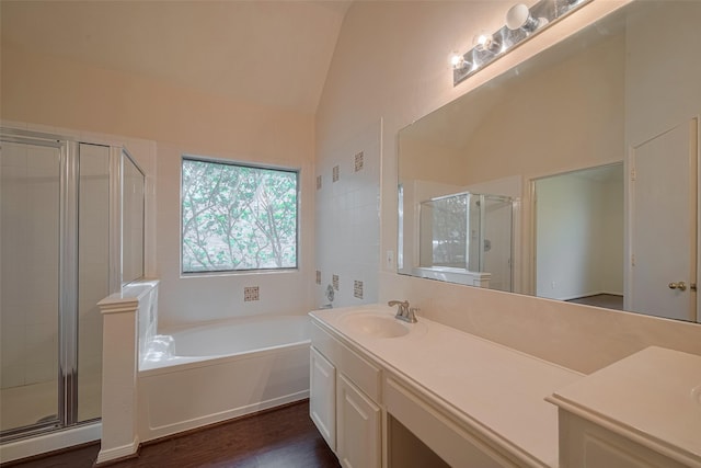 619 Bending Bough Dr, Spring, TX 77388 - full bathroom featuring vanity, a stall shower, a garden tub, wood finished floors, and high vaulted ceiling