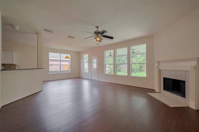 619 Bending Bough Dr, Spring, TX 77388 - unfurnished living room featuring wood finished floors, a tiled fireplace, and a ceiling fan