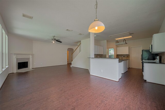 619 Bending Bough Dr, Spring, TX 77388 - unfurnished living room with dark wood-type flooring, a ceiling fan, a fireplace with flush hearth, and stairs