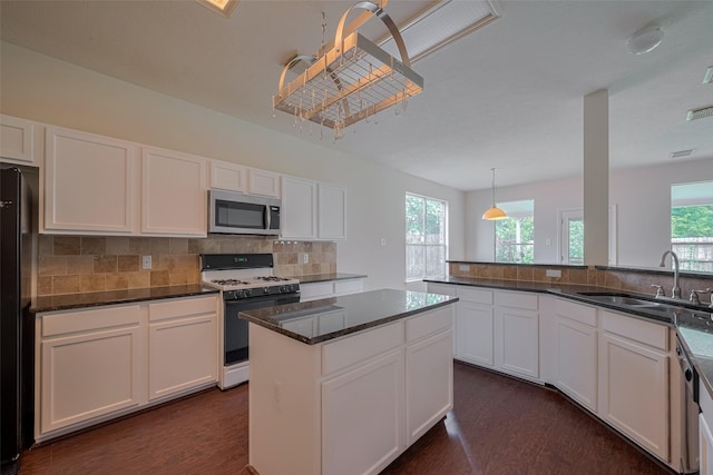 619 Bending Bough Dr, Spring, TX 77388 - kitchen with appliances with stainless steel finishes, healthy amount of natural light, dark wood finished floors, and white cabinets