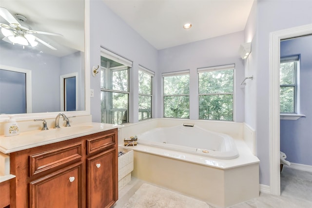 19426 Indigo Lake Dr, Magnolia, TX 77355 - bathroom with a tub with jets, vanity, a ceiling fan, and tile patterned flooring